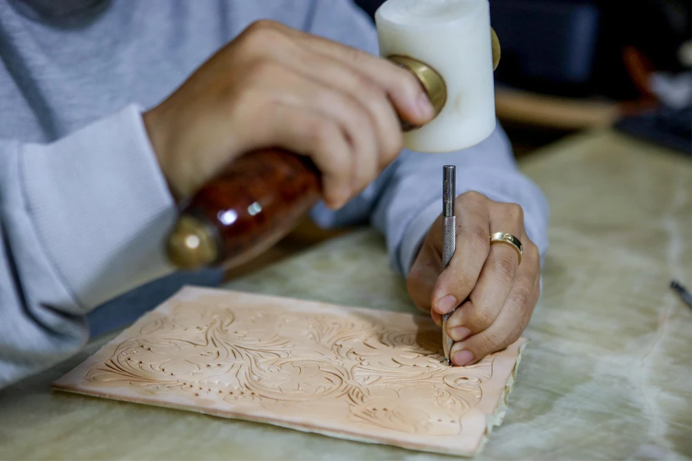 Anh Tuấn dùng búa đẽo cẩn thận từng nét tránh làm hỏng tấm da.