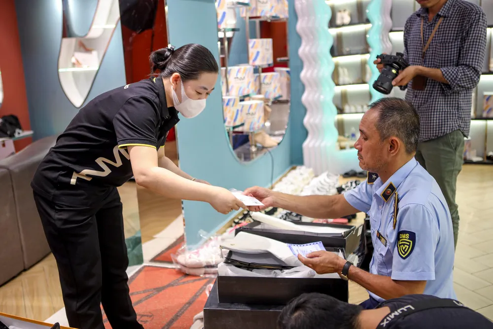 Nhân viên cửa hàng phối hợp với quản lý thị trường trong ngày làm việc.