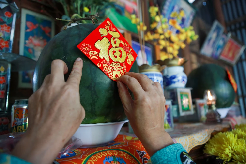 Cặp dưa hấu là phẩm vật không thể thiếu trên bàn thờ gia tiên của gia đình bà Út. Bàn thờ gia tiên của người miền Tây ngày Tết