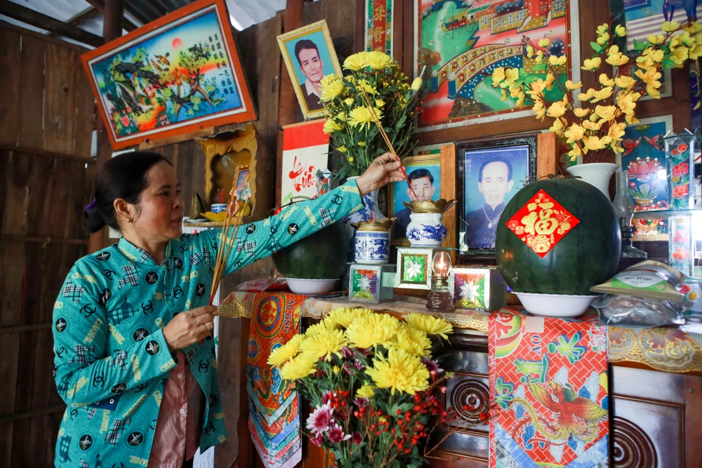 Bà Dương Thị Út cúng rước ông bà trong ngày 30 Tết. Bàn thờ gia tiên của người miền Tây ngày Tết
