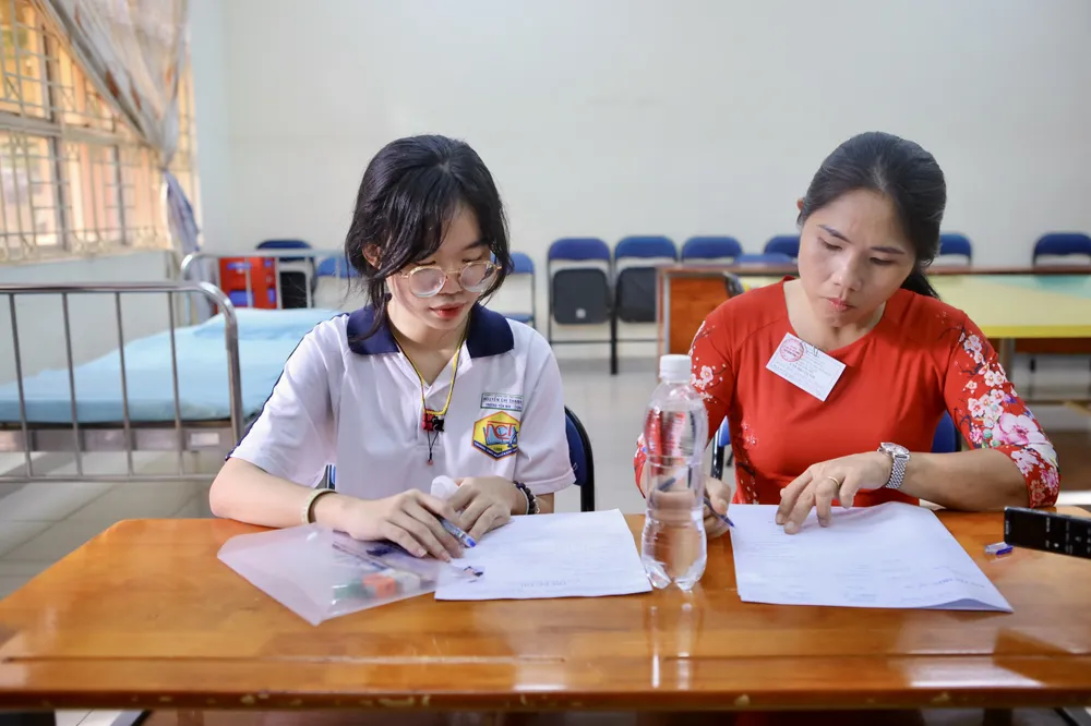 Trương Yến Nhi được thầy cô hỗ trợ tận tình trong kì thi. Ảnh: NGUYỆT NHI Kì thi Tốt nghiệp THPT 2024: Thí sinh đặc biệt được cán bộ túc trực để viết bài hộ