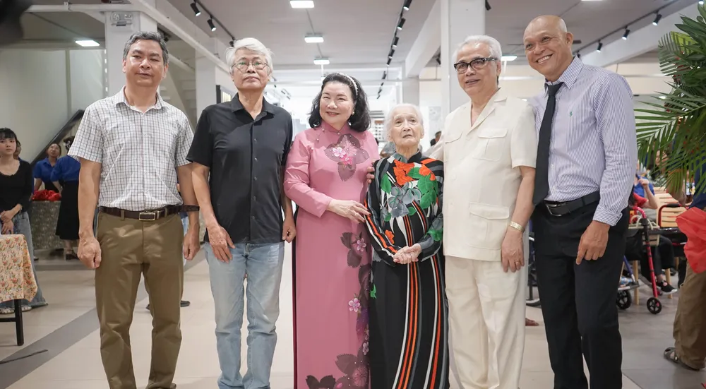 Các khách mời, khán giả giao lưu chụp hình lưu niệm cùng tác giả Nguyễn Á. Ảnh: PHƯỚC HUỆ Triển lãm ảnh 70 năm Điện Biên Phủ của Nhiếp ảnh gia Nguyễn Á