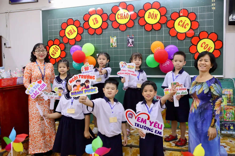 Cô Lê Qúy Ngân (bìa trái), giáo viên lớp 1B cùng cô bảo mẫu chụp ảnh kỷ niệm cùng các em. Ảnh: NGUYỆT NHI Trường học TP.HCM rộn ràng ngày hội “Em vào lớp 1”
