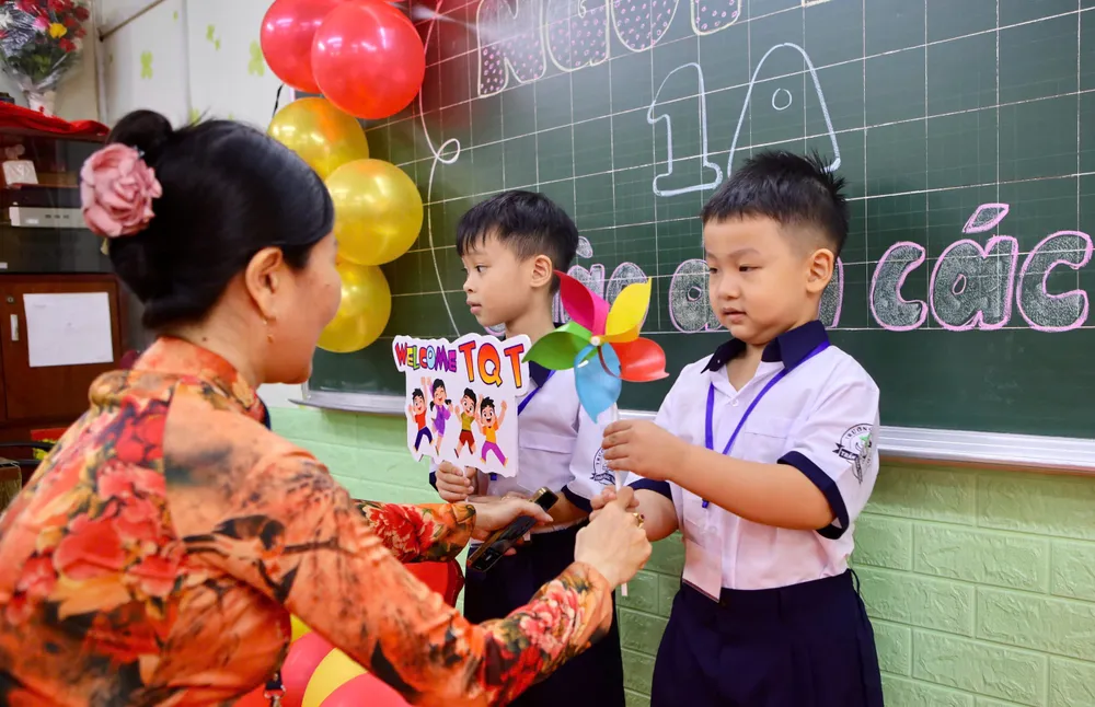 Các em học sinh được các cô hướng dẫn làm quen bạn mới. Ảnh: NGUYỆT NHI Trường học TP.HCM rộn ràng ngày hội “Em vào lớp 1”