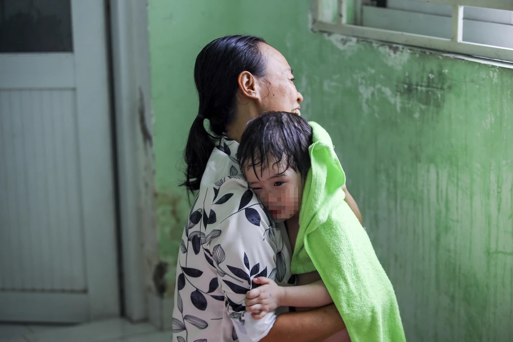 Bà Hiên cùng các cô bảo mẫu tắm cho các em nhỏ. Ảnh: NGUYỆT NHI Ngôi nhà mới của những em bé mái ấm Hoa Hồng