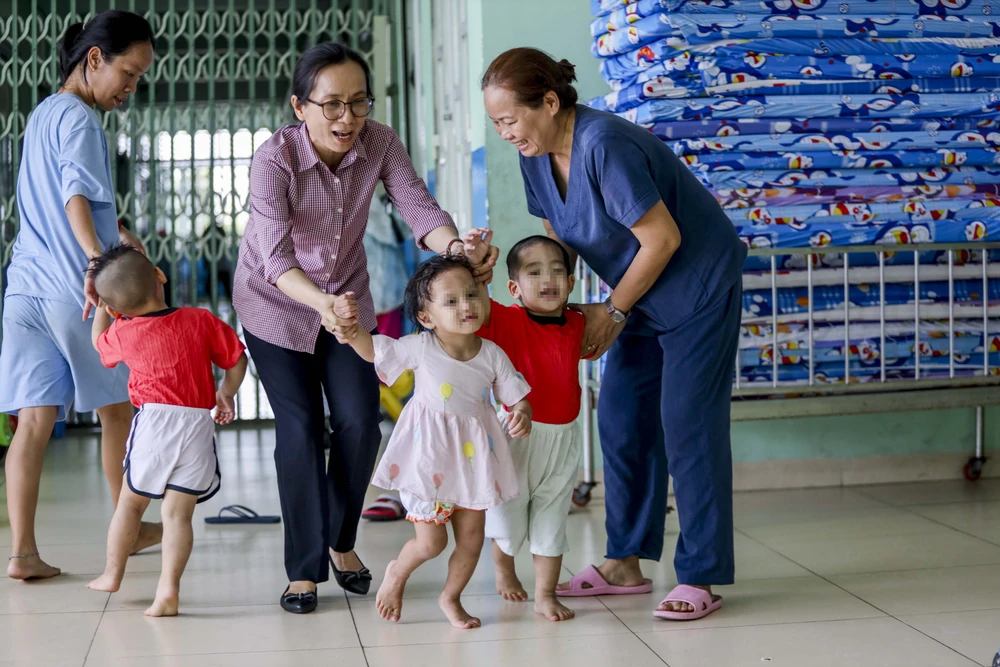 Các em nhỏ mái ấm Hoa Hồng được các cô chăm sóc. Ảnh: NGUYỆT NHI Ngôi nhà mới của những em bé mái ấm Hoa Hồng