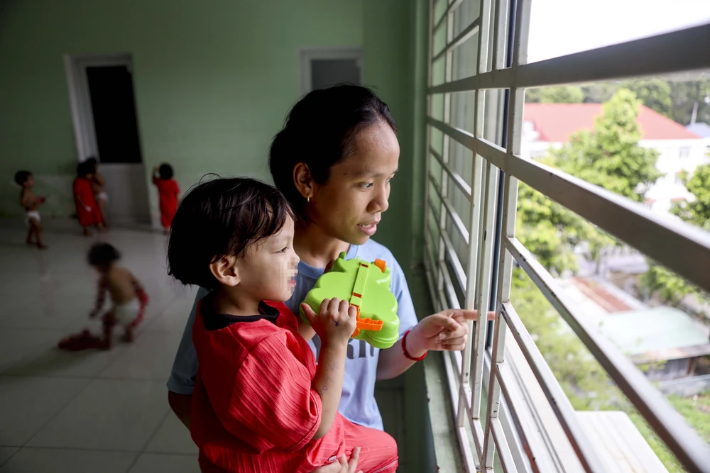 Các bé lớn tại trung tâm giúp các cô trông em và chơi cùng. Ảnh: NGUYỆT NHI Ngôi nhà mới của những em bé mái ấm Hoa Hồng