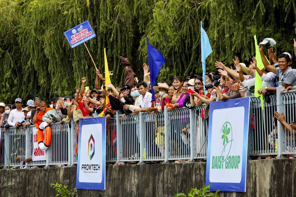 Dọc theo hai bờ kênh, người dân chen kín để xem các đội tranh tài. Tiếng hò reo giòn giã khích lệ tinh thần của các vận động viên đua ghe ngo.