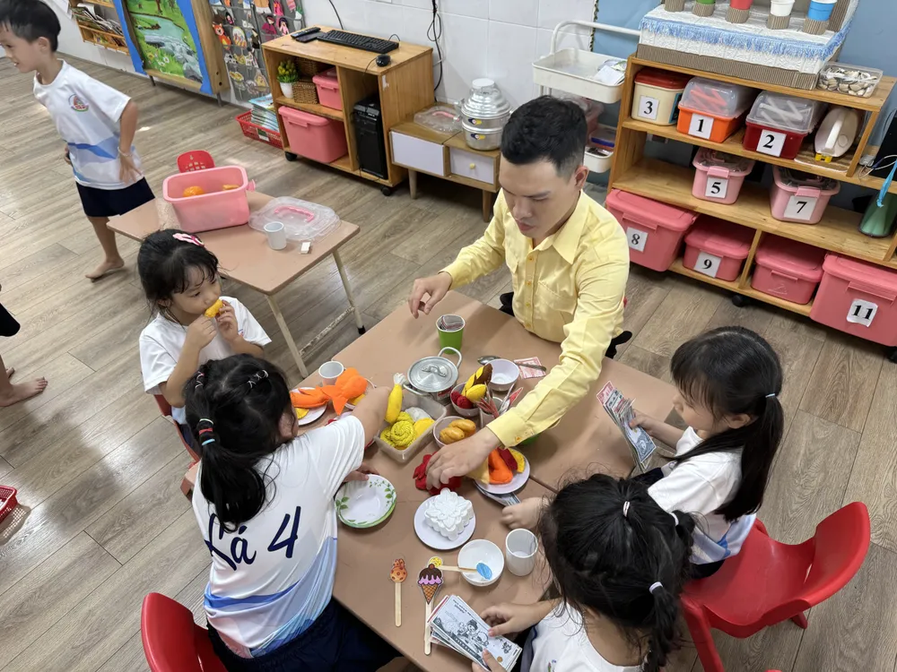 Thầy Lê Công Sự, giáo viên mầm non trường Mầm non Hoa Đào (Quận 12) sinh hoạt cùng các em nhỏ. Ảnh: KHÁNH QUỲNH