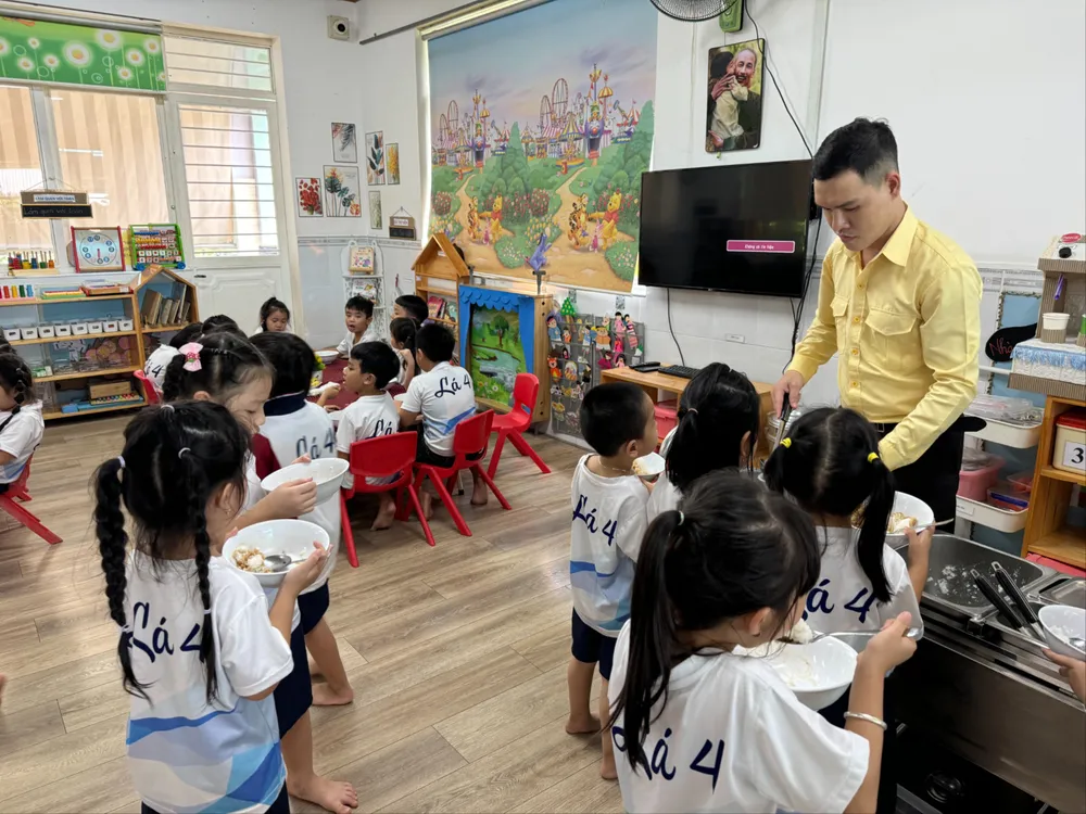 Thầy Lê Công Sự, giáo viên mầm non trường Mầm non Hoa Đào (Quận 12) sinh hoạt cùng các em nhỏ. Ảnh: KHÁNH QUỲNH