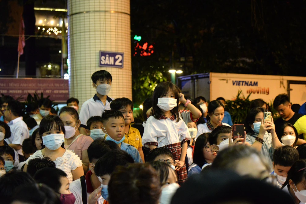 Các em nhỏ chăm chú theo dõi chương trình văn nghệ.