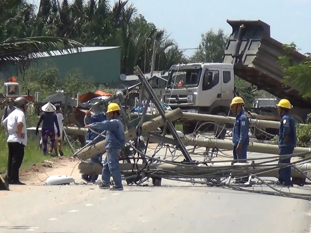 Chiếc xe tải hạng nặng kéo đổ nhiều cột điện tại huyện Bình Chánh ngày 25-9.