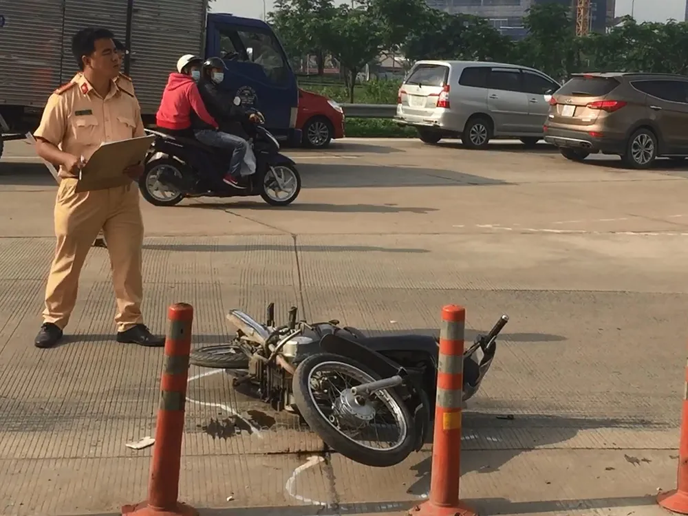 Lực lượng chức năng khám nghiệm hiện trường, điều tra nguyên nhân vụ tai nạn giữa xe máy và container.