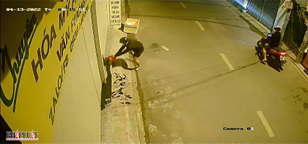 Thanh niên tới tạt nhớt trước cửa hàng buôn bán của người dân trên địa bàn phường Sơn Kỳ, quận Tân Phú. Ảnh chụp từ clip