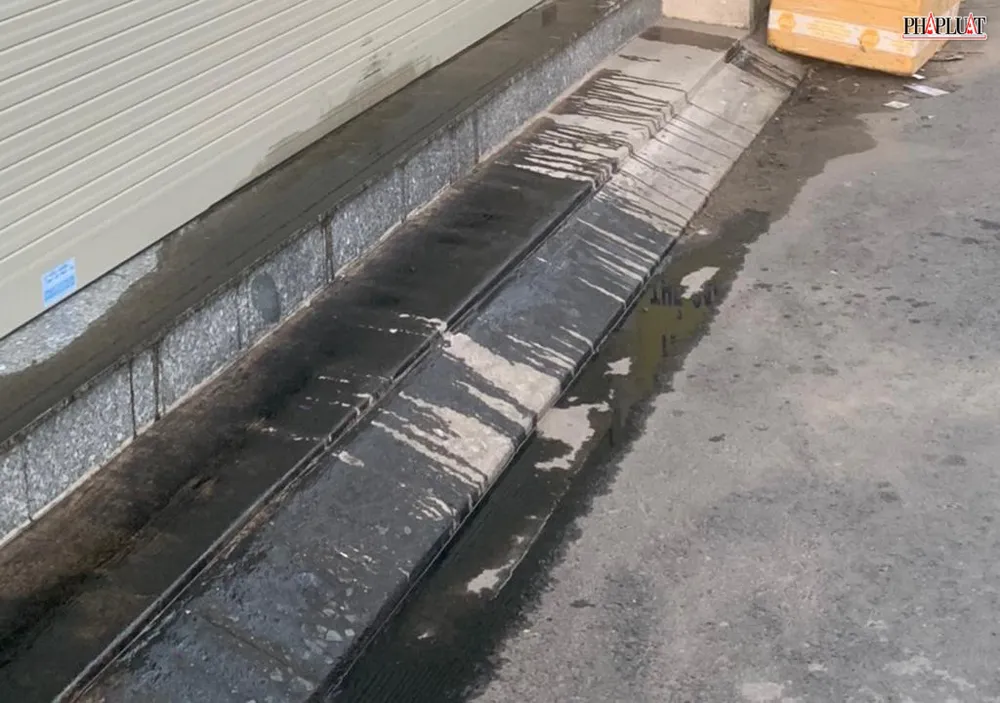 Nhớt tràn từ cửa hàng ra lòng đường trước nơi bà P buôn bán. Ảnh: NT