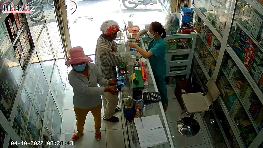 Hôm 10-4, hai người này đến hiệu thuốc trên địa bàn quận Gò Vấp dàn cảnh, lấy thuốc. Ảnh chụp từ clip