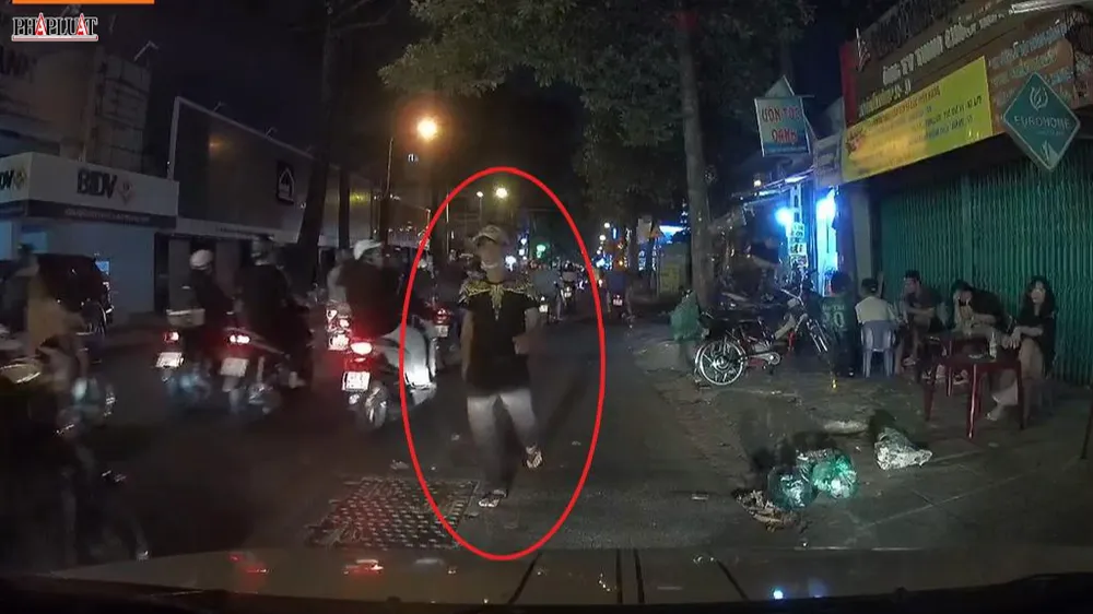 Người đàn ông đi bộ tới xe ô tô của anh T rồi đập cửa, xin 20 ngàn mua cây kim. Ảnh chụp từ clip