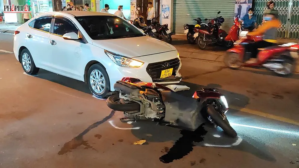 Sau va chạm, chiếc xe máy của nạn nhân trượt dài trên đường, va trúng một ô tô. Ảnh: HT Sau va chạm, chiếc xe máy của nạn nhân trượt dài trên đường, va trúng một ô tô. Ảnh: HT