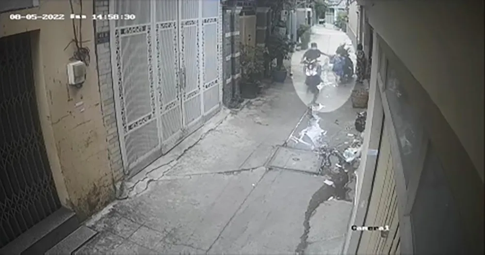 Nam thanh niên chạy xe máy cướp giật iPad trên tay bé trai trong con hẻm. Ảnh chụp từ clip Nam thanh niên chạy xe máy cướp giật iPad trên tay bé trai trong con hẻm. Ảnh chụp từ clip