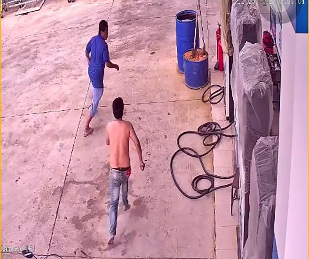 Hạnh tay cầm kéo tấn công các nhân viên cây xăng. Ảnh chụp từ clip