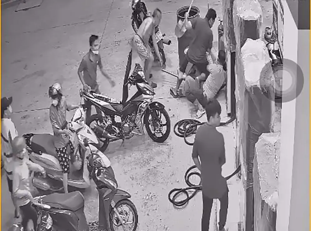 Trước đó, Hạnh vào cây xăng đổ xăng, hút thuốc, bị nhắc nhở và xô xát với hai nhân viên cây xăng. Ảnh chụp từ clip