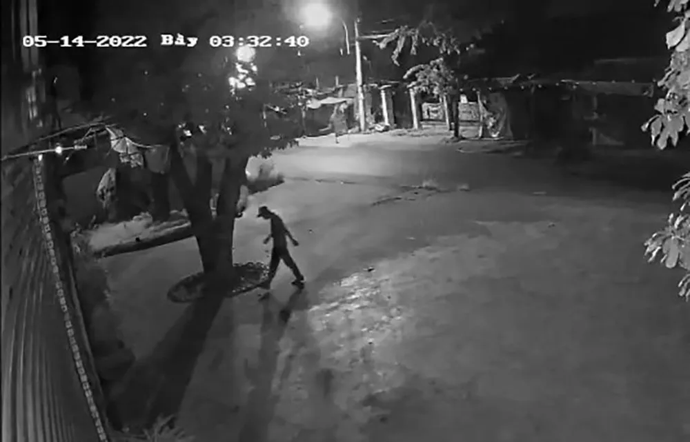 Nam thanh niên đi bộ rình trước quán cà phê rồi tiếp cận. Ảnh chụp từ clip