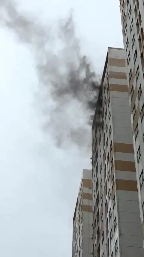 Khói đen bốc lên từ căn hộ ở tầng cao chung cư khiến người dân phải di chuyển xuống bên dưới. Ảnh: HT