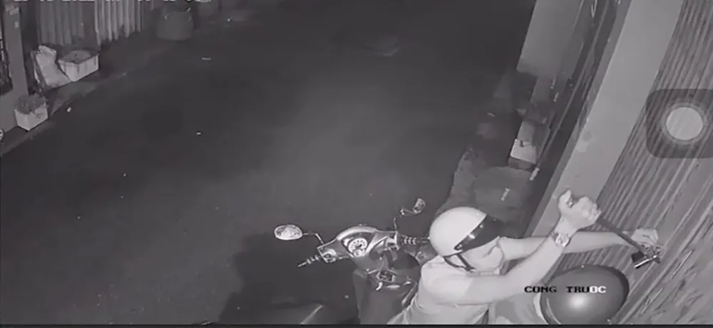 Một người dùng dụng cụ cạy khóa cửa. Ảnh chụp từ clip