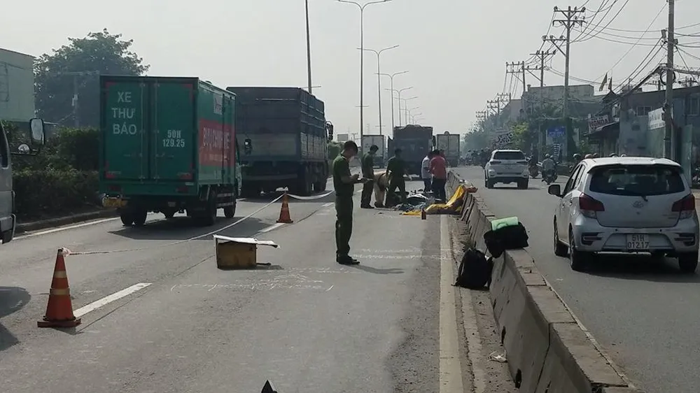 Hai người tử vong bên cạnh xe máy trong làn xe ô tô trên quốc lộ 1 sau va chạm xe tải. Ảnh: HT