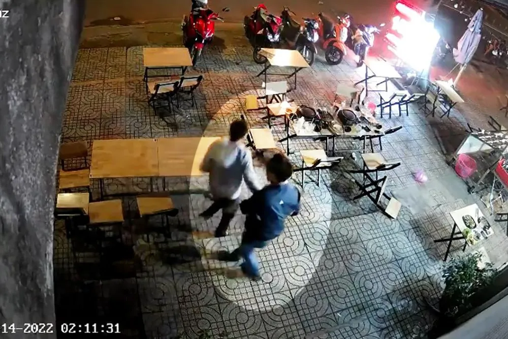 Người đi cùng kéo nghi phạm rời đi. Ảnh chụp từ clip Người đi cùng kéo nghi phạm rời đi. Ảnh chụp từ clip