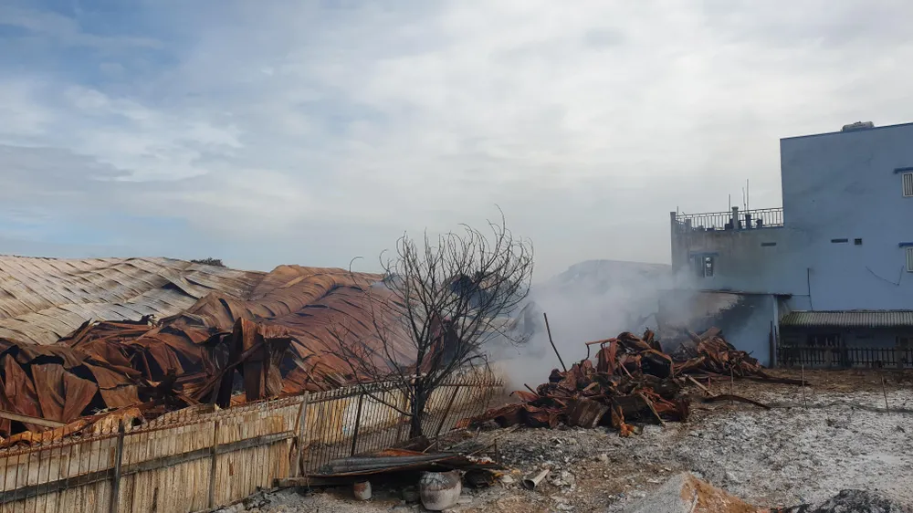 Đến sáng ngày 14-7, khói vẫn bốc lên từ nhà xưởng này. Ảnh: NT