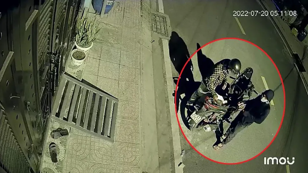 Sau đó, cả hai cùng đứng mở cốp xe máy kiểm tra, vứt lại giấy tờ không có giá trị. Ảnh chụp từ clip Sau đó, cả hai cùng đứng mở cốp xe máy kiểm tra, vứt lại giấy tờ không có giá trị. Ảnh chụp từ clip