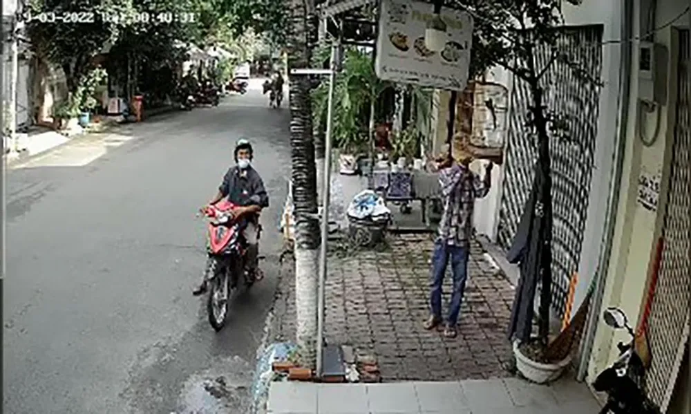 Nam thanh niên tiếp cận, lấy lồng chim của ông Khuyên. Ảnh chụp từ clip Nam thanh niên tiếp cận, lấy lồng chim của ông Khuyên. Ảnh chụp từ clip