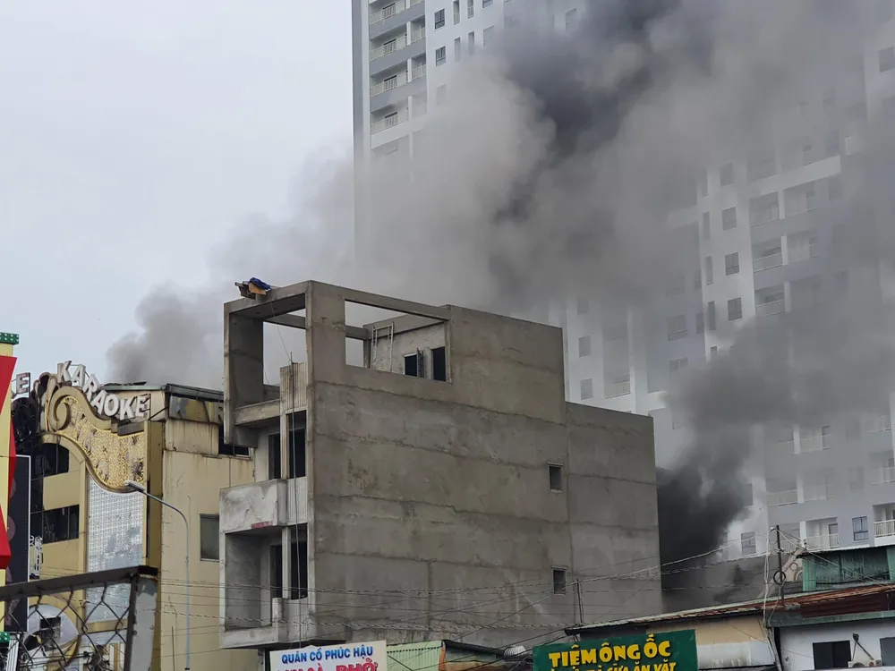 Khói dữ dội vẫn bốc ra từ bên trong quán karaoke. Ảnh: THƠ TÂN
