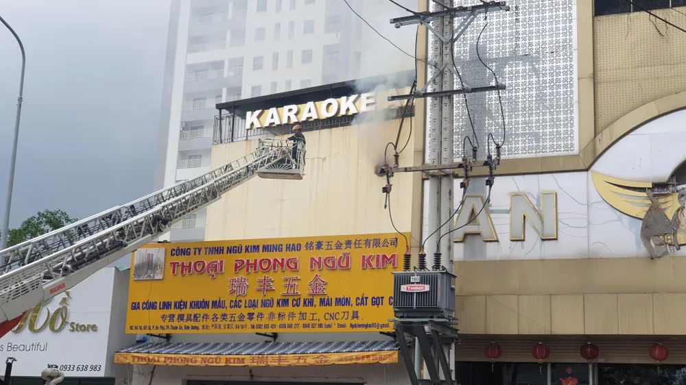 Cảnh sát đục tường để hút khói bên trong ra ngoài. Ảnh: THƠ TÂN