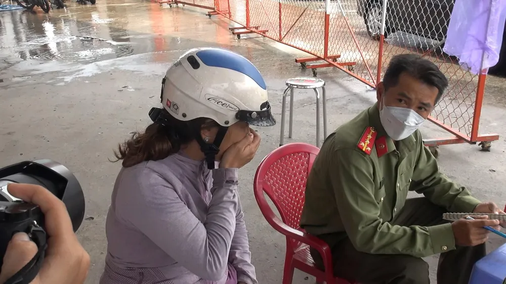 Người phụ nữ khóc, trình báo thông tin với công an tại hiện trường. Ảnh: TÂN THƠ