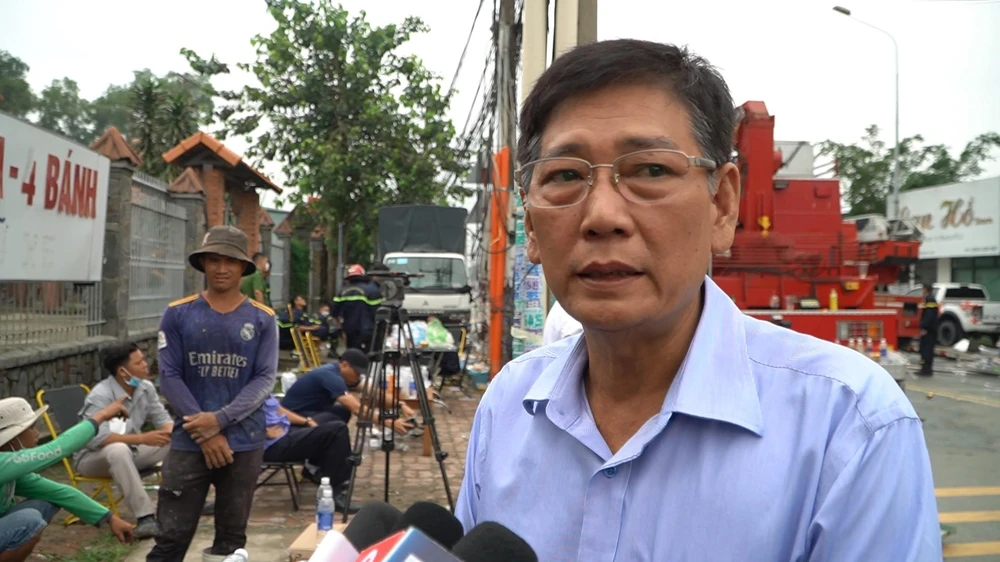 Ông Dũng thông tin ban đầu về vụ cháy ở hiện trường. Ảnh: TÂN THƠ