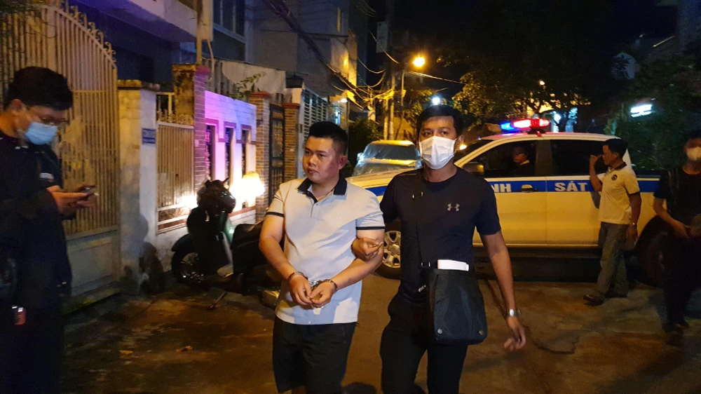 Thạch (áo trắng) bị đưa về căn nhà ở quận Bình Tân để công an thực hiện việc khám xét. Ảnh: NT Thạch (áo trắng) bị đưa về căn nhà ở quận Bình Tân để công an thực hiện việc khám xét. Ảnh: NT