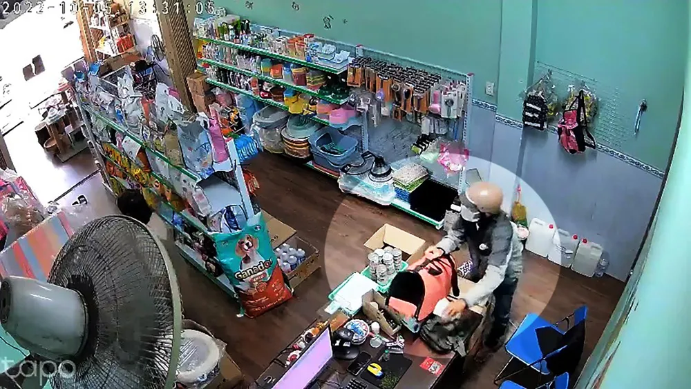Người đàn ông dàn cảnh mua hàng, khéo léo trộm tiền của chủ tiệm. Ảnh chụp từ clip