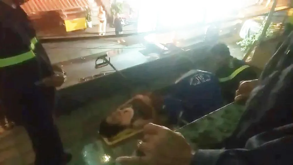 Người phụ nữ rơi từ lầu ba xuống mái tole ở tầng 1 được lực lượng chức năng tiếp cận, giải cứu. Ảnh: PC07