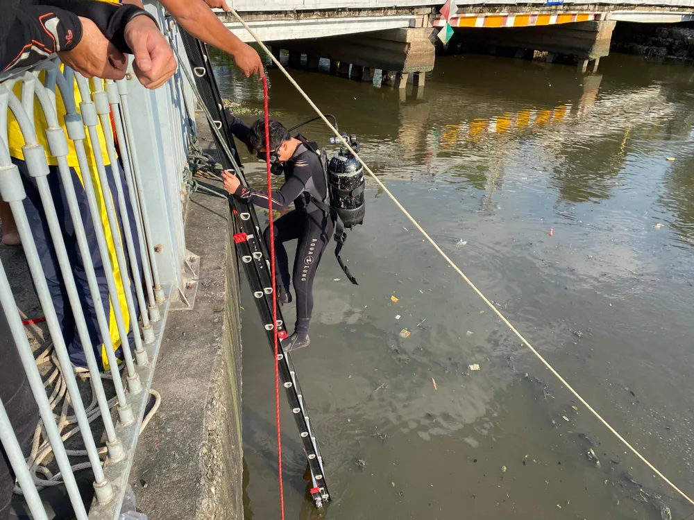 Người nhái mang đồ chuyên dụng lặn tìm dưới kênh Nhiêu Lộc - Thị Nghè. Ảnh: CA
