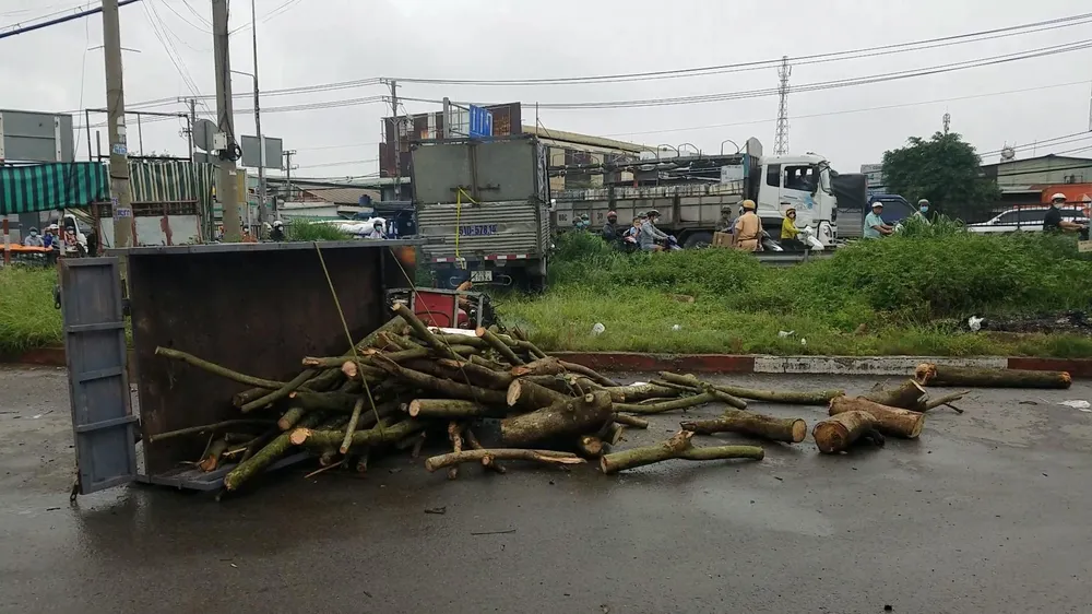 Chiếc xe ba gác máy chở củi bị tông ngã ra đường. Ảnh: HT