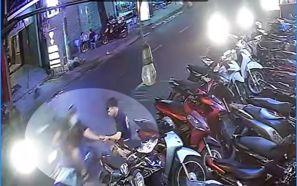 Nam sinh viên đang đứng trông xe trong giờ làm thêm thì bị cướp giật điện thoại. Ảnh chụp từ clip