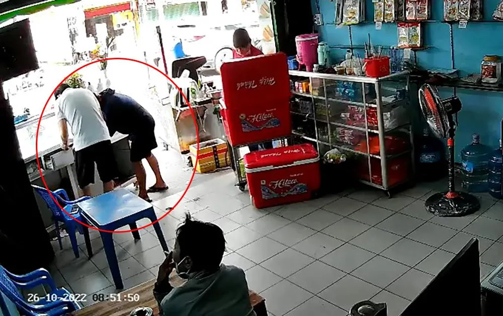 Người đàn ông cho tay vào hộc tủ của anh T ra hiệu. Ảnh chụp từ clip