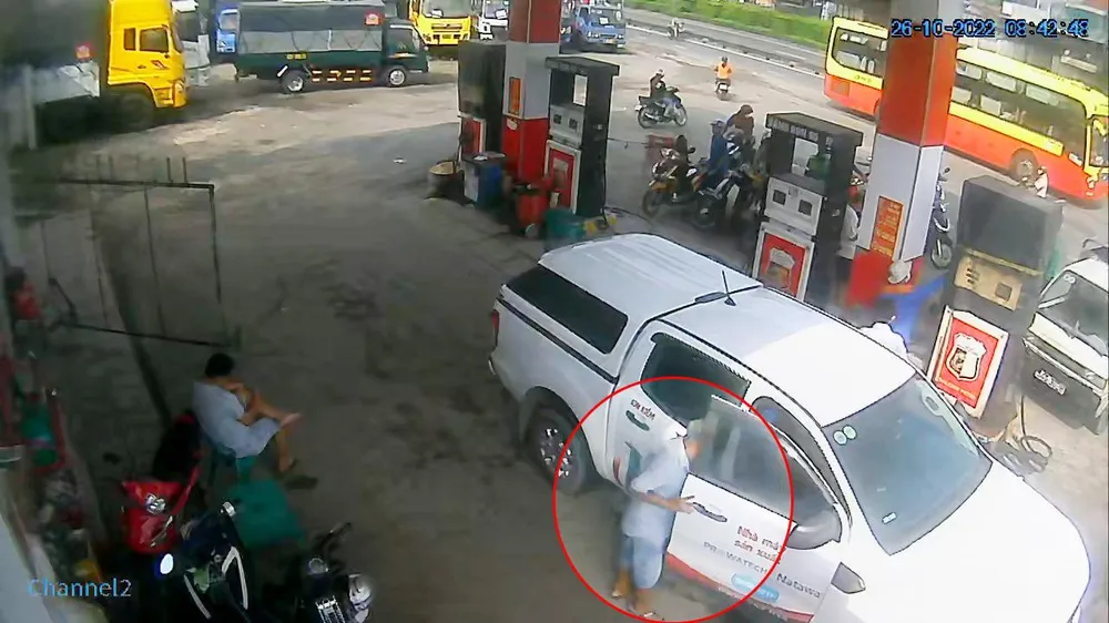 Người đàn ông sau khi quan sát thì mở cửa ô tô của anh T đang đổ dầu. Ảnh chụp từ clip Người đàn ông sau khi quan sát thì mở cửa ô tô của anh T đang đổ dầu. Ảnh chụp từ clip