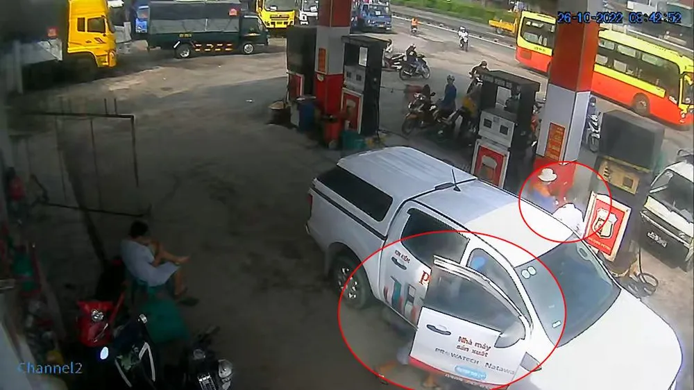 Kẻ gian chui hẳn người vào bên trong xe trong lúc anh T đang mải đổ dầu. Ảnh chụp từ clip Kẻ gian chui hẳn người vào bên trong xe trong lúc anh T đang mải đổ dầu. Ảnh chụp từ clip
