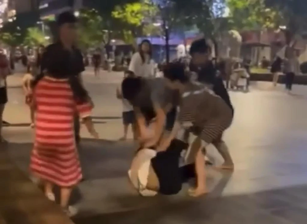 Trước đó, trên mạng xã hội lan truyền đoạn clip hai thanh niên bị nhóm người bán hàng rong tấn công bị thương ở phố đi bộ Nguyễn Huệ. Ảnh chụp từ clip
