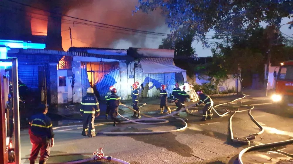 Cảnh sát phá cửa, chia nhiều mũi khống chế đám cháy, không để lan rộng. Ảnh: NT