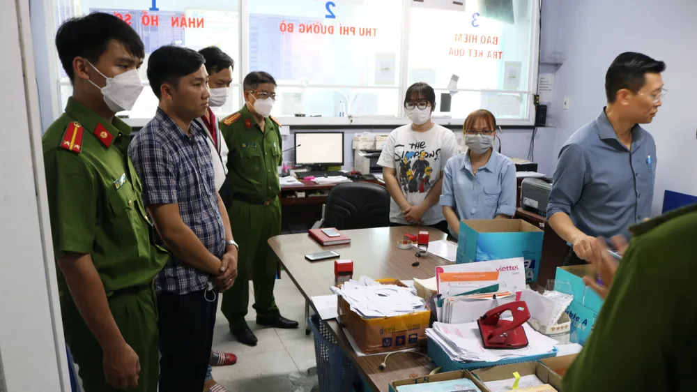 Công an thực hiện lệnh khám xét, bắt ông Lực (áo kẻ ka-rô bên trái) về tội nhận hối lộ. Ảnh: CA