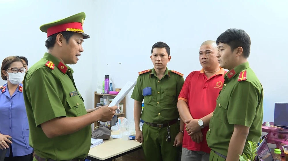 Công an đọc lệnh bắt, khám xét với những người liên quan tại Công ty cổ phần mua bán nợ Việt Nam Thịnh Vượng. Ảnh: CA